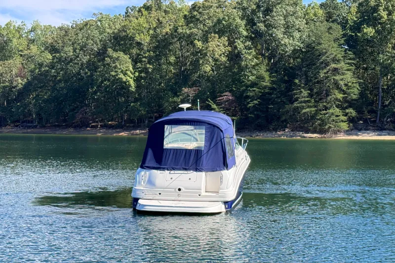 Slide: The Image of 2005 Sea Ray 280 Sundancer boat on a serene lake with forested background. - 12
