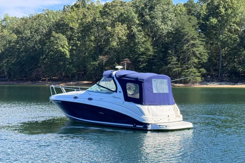 Slide: The Image of 2005 Sea Ray 280 Sundancer boat on a serene lake with forested background. - 13