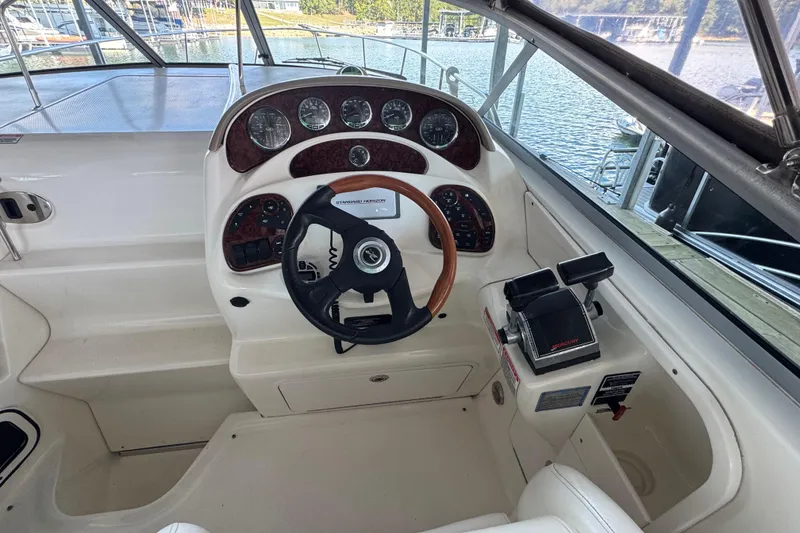 Slide: The Image of 2005 Sea Ray 280 Sundancer helm with steering wheel and control panel, dockside view. - 16