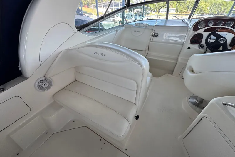 Slide: The Image of 2005 Sea Ray 280 Sundancer interior with white seating and helm, showcasing luxury design. - 18