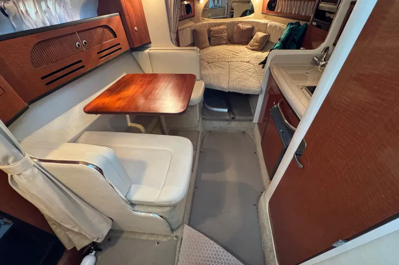 Slide: The Image of Interior of 2005 Sea Ray 280 Sundancer with dining area and cozy sleeping space. - 21