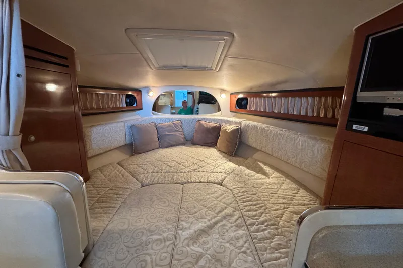 Slide: The Image of 2005 Sea Ray 280 Sundancer cabin interior with cozy bedding and elegant wood accents. - 22