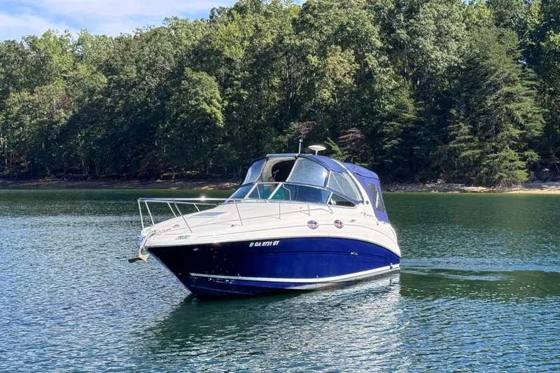 Slide: The Image of 2005 Sea Ray 280 Sundancer boat on a serene lake with forested shoreline. - 3