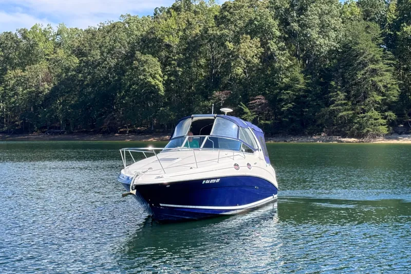 Slide: The Image of 2005 Sea Ray 280 Sundancer boat on a serene lake with forested background. - 4