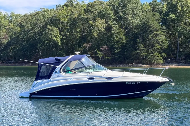 Slide: The Image of 2005 Sea Ray 280 Sundancer boat on a serene lake with forested background. - 6