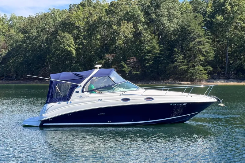 Slide: The Image of 2005 Sea Ray 280 Sundancer boat on a calm lake with forested shoreline. - 7