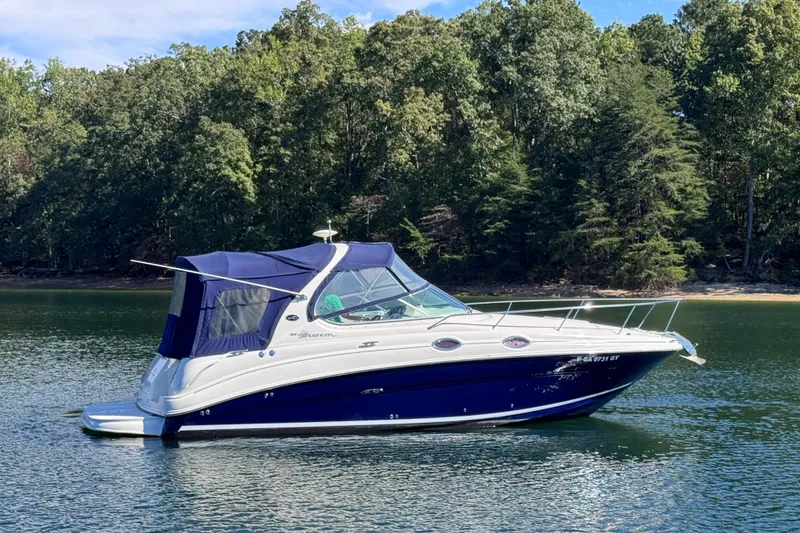 Slide: The Image of 2005 Sea Ray 280 Sundancer boat on a serene lake with lush forest backdrop. - 8