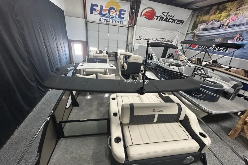 Slide: The Image of 2025 Barletta Lusso 25UE pontoon boat displayed in a showroom with other boats. - 9