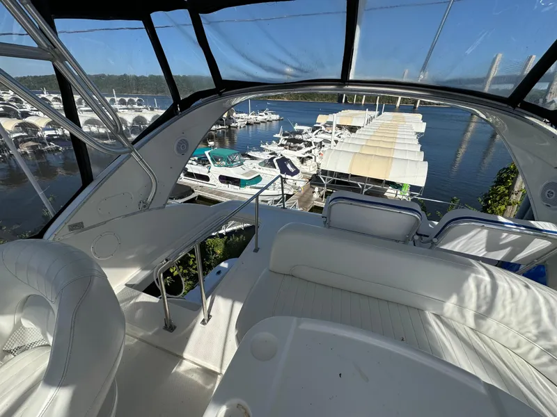 Slide: The Image of 2004 Meridian 381 Sedan interior with marina view, featuring white seating and table. - 13
