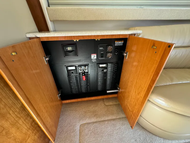 Slide: The Image of Electrical panel inside a 2004 Meridian 381 Sedan yacht, with open wooden cabinet doors. - 28