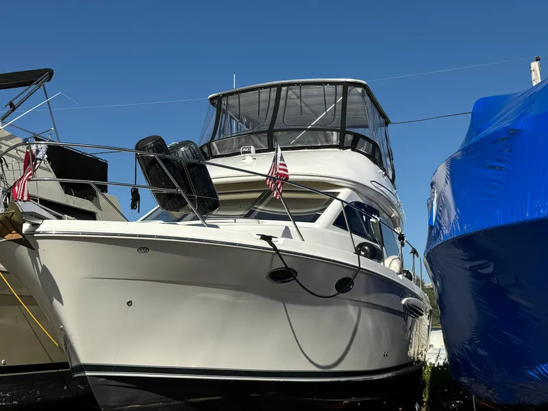 Slide: The Image of 2004 Meridian 381 Sedan yacht docked with American flags, clear blue sky background. - 3
