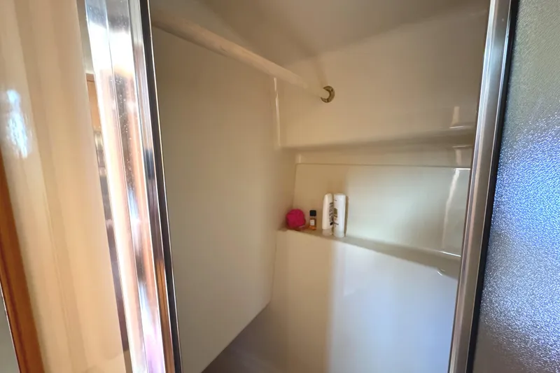 Slide: The Image of Shower area inside a 2004 Meridian 381 Sedan boat, featuring toiletries and a towel. - 45