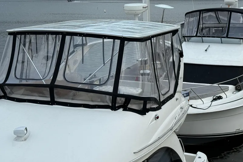 Slide: The Image of 2004 Meridian 381 Sedan boats docked with clear enclosures on a calm waterway. - 82