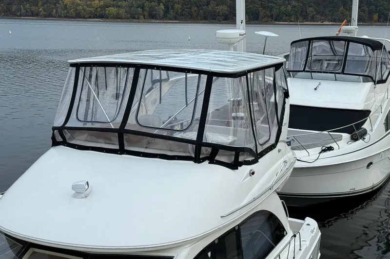 Slide: The Image of 2004 Meridian 381 Sedan yacht docked on a calm lake with clear enclosure. - 83