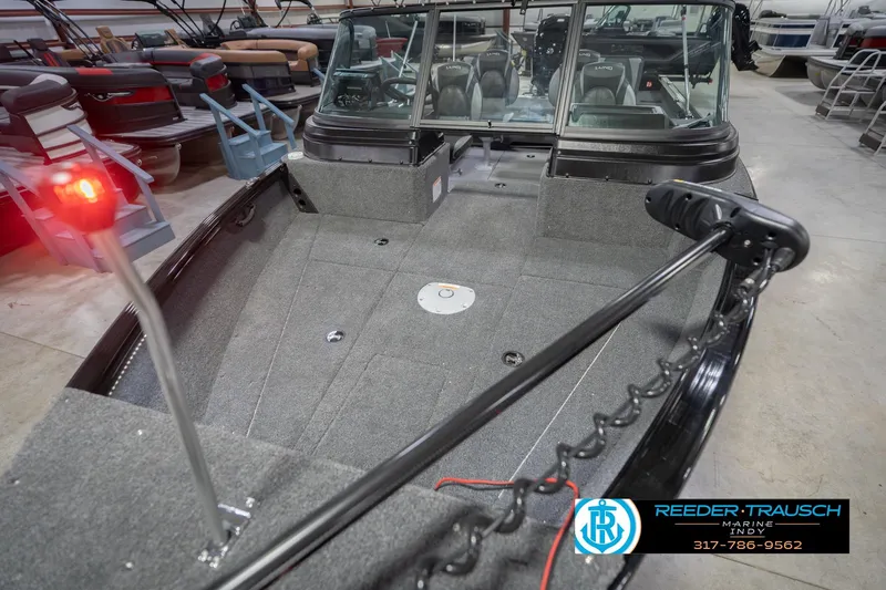 Slide: The Image of 2026 Lund 1875 Impact XS boat interior with seating and control panel in showroom. - 12