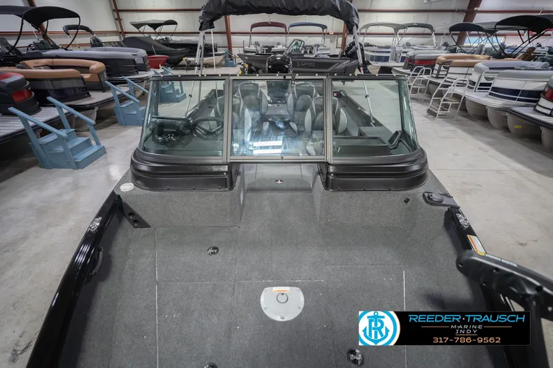 Slide: The Image of 2026 Lund 1875 Impact XS boat in showroom, featuring spacious interior and windshield. - 19