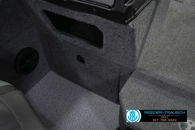 Slide: The Image of 2026 Lund 1875 Impact XS interior with carpeted storage and speaker detail. - 27