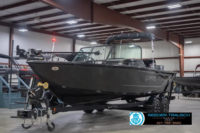 Slide: The Image of 2026 Lund 1875 Impact XS boat in showroom, black exterior, on trailer. - 3