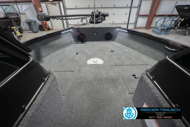 Slide: The Image of 2026 Lund 1875 Impact XS boat interior with carpeted deck and trolling motor. - 31