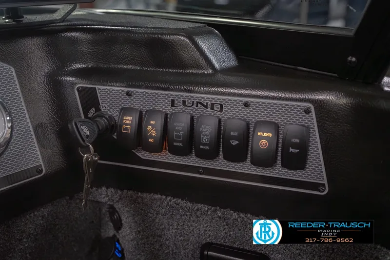 Slide: The Image of Control panel of 2026 Lund 1875 Impact XS boat with illuminated switches and key ignition. - 38