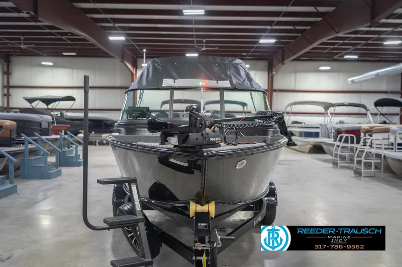 Slide: The Image of 2026 Lund 1875 Impact XS boat in showroom, featuring sleek design and modern equipment. - 5