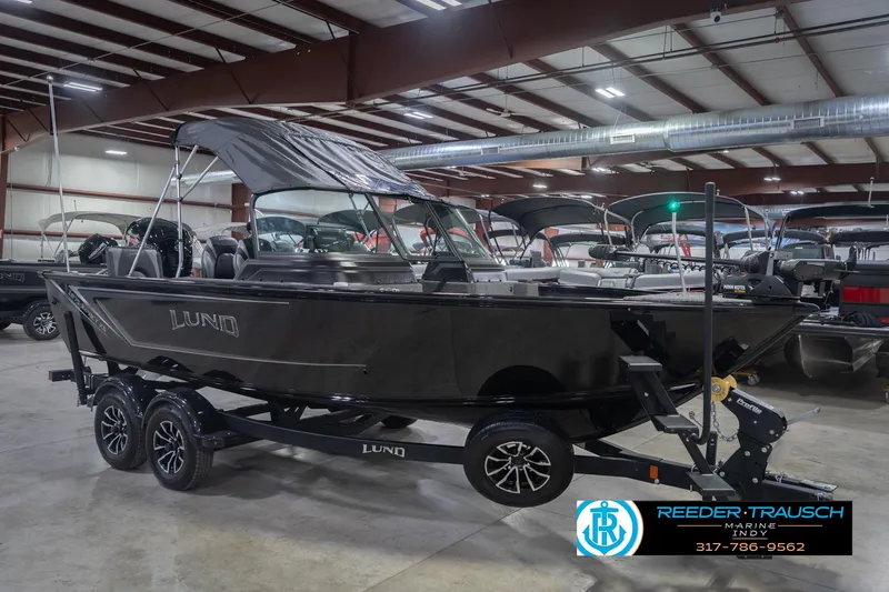 Slide: The Image of 2026 Lund 1875 Impact XS boat in showroom, black exterior, on trailer. - 6