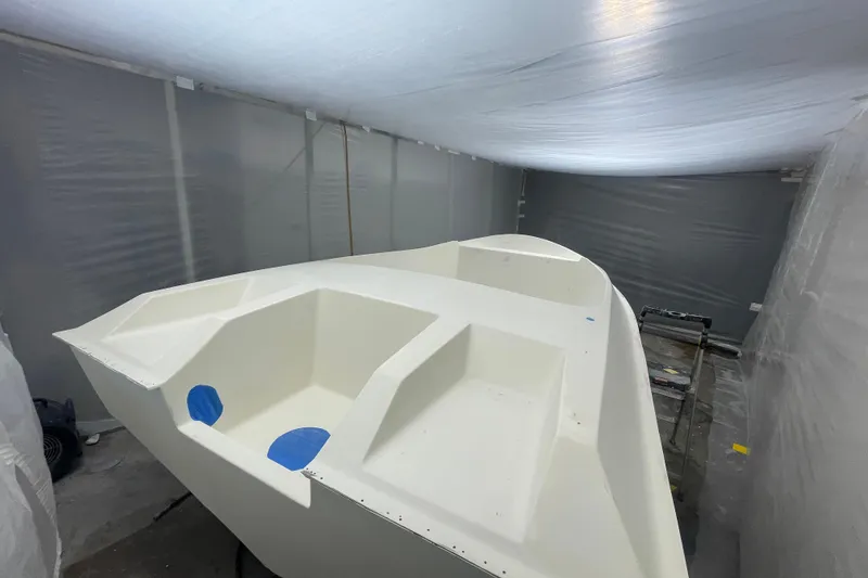 Slide: The Image of 1985 JJM VS boat hull in a workshop, under construction with protective covering. - 11