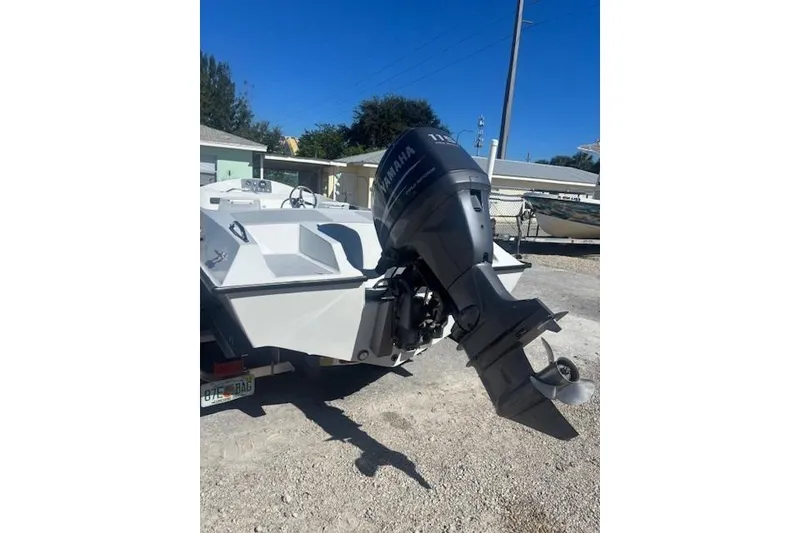 Slide: The Image of Boat with Yamaha outboard motor, JJM VS 1985 model, parked on gravel driveway. - 4