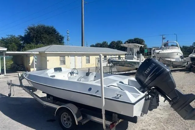 Slide: The Image of White JJM VS 1985 boat on trailer with Yamaha motor, parked outdoors. - 5
