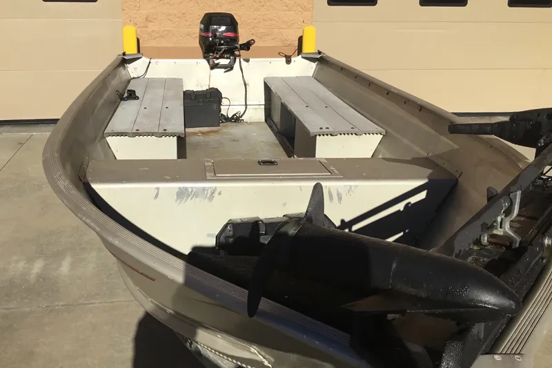 Slide: The Image of 2000 Tracker Guide V-14 Laker boat with motor, parked on concrete surface. - 3