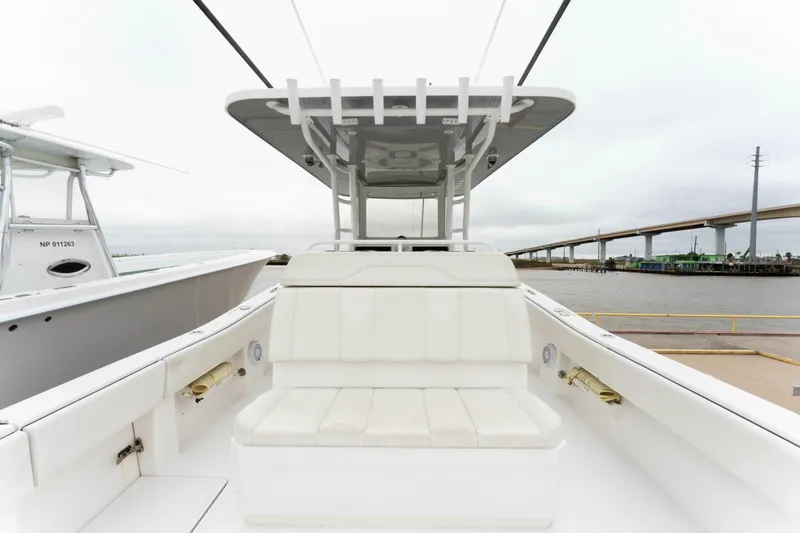 Slide: The Image of 2019 Invincible 39 Open Fisherman boat with white seating and T-top, docked near a bridge. - 11