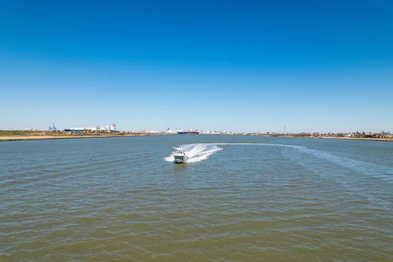 Slide: The Image of 2019 Invincible 39 Open Fisherman cruising on a wide river under clear blue skies. - 40