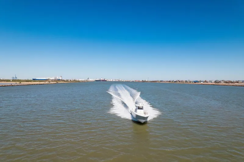 Slide: The Image of 2019 Invincible 39 Open Fisherman boat cruising on a wide river under clear blue skies. - 41