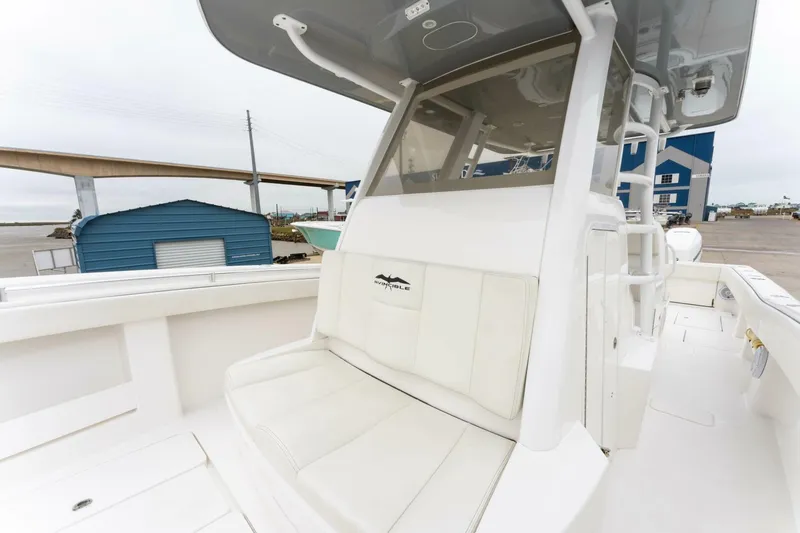 Slide: The Image of 2019 Invincible 39 Open Fisherman boat with white seating and console, dockside view. - 8