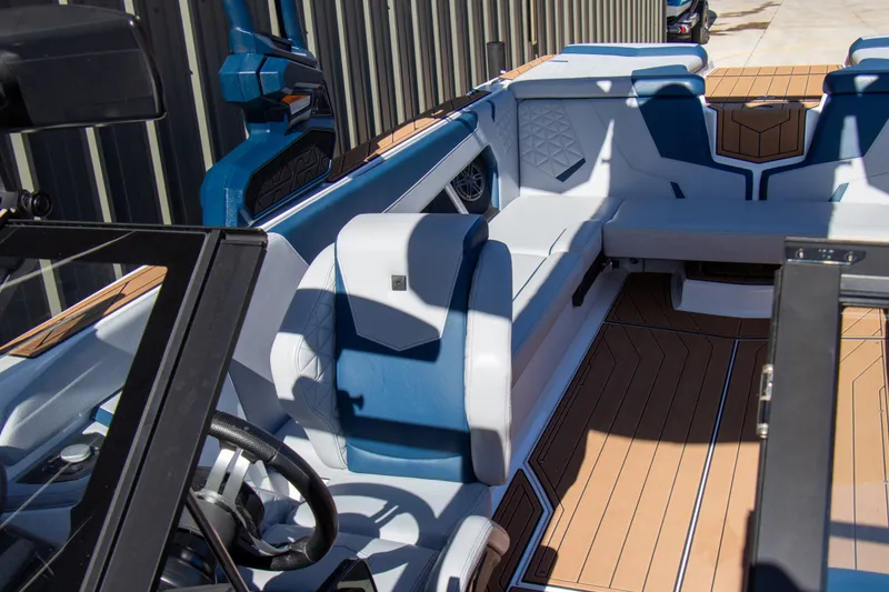 Slide: The Image of 2026 Nautique Super Air Nautique GS24 interior with blue and white seating, wood flooring. - 12