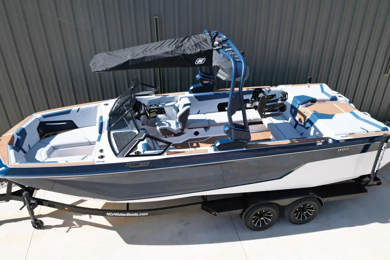 Slide: The Image of 2026 Nautique Super Air Nautique GS24 boat on trailer, sleek design, blue and white color scheme. - 26
