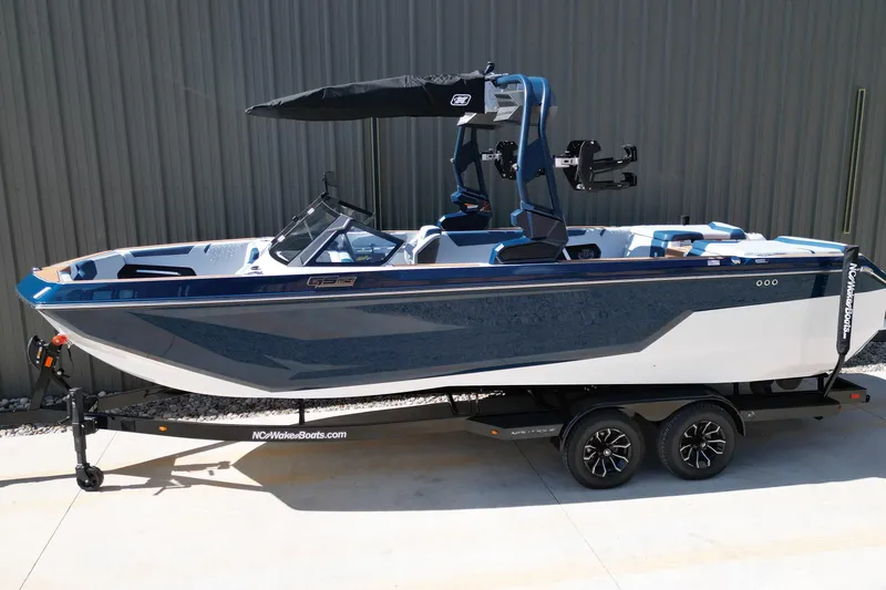 Slide: The Image of 2026 Nautique Super Air Nautique GS24 boat on trailer, blue and white design. - 27