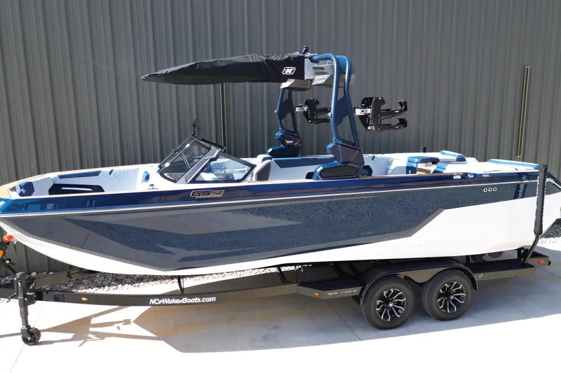 Slide: The Image of 2026 Nautique Super Air Nautique GS24 boat on trailer, blue and white design. - 28