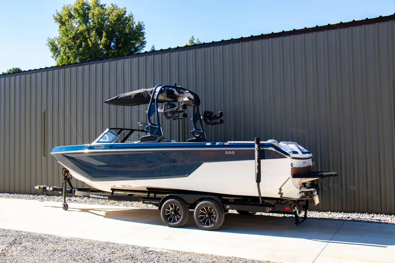 Slide: The Image of 2026 Nautique Super Air Nautique GS24 boat on trailer, parked outdoors. - 3