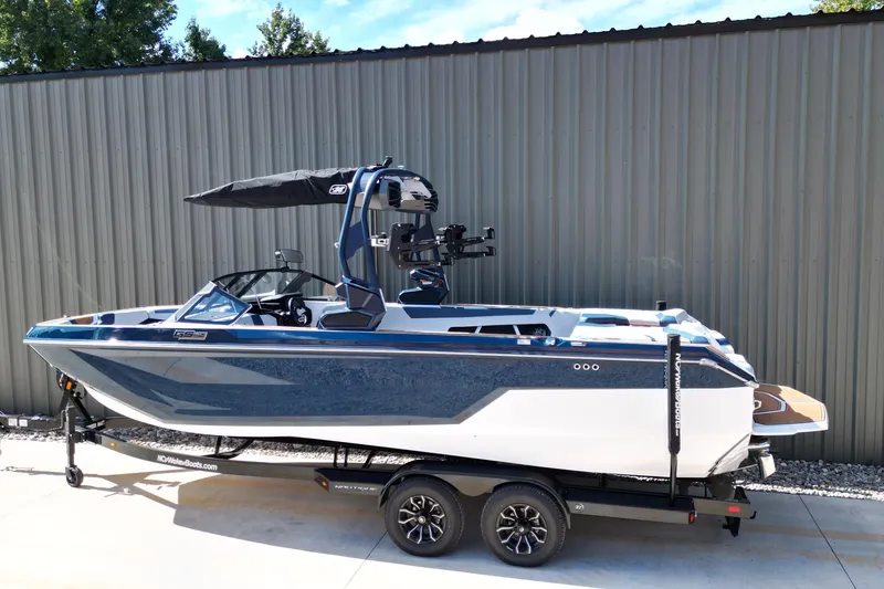 Slide: The Image of 2026 Nautique Super Air Nautique GS24 boat on trailer, blue and white design. - 4