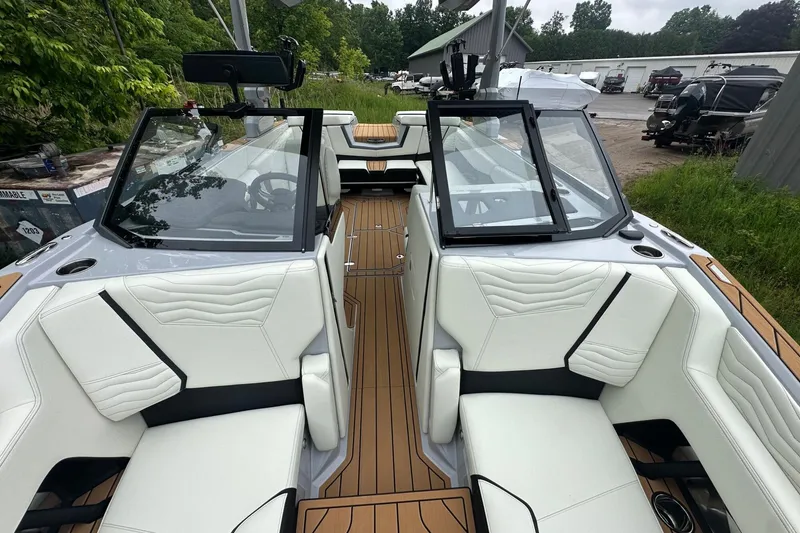Slide: The Image of 2025 Nautique Super Air Nautique G23 interior with white seating and wood accents. - 22