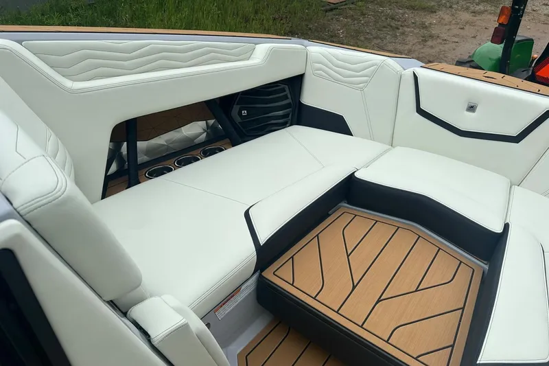 Slide: The Image of 2025 Nautique Super Air Nautique G23 interior with luxurious white seating and teak flooring. - 26
