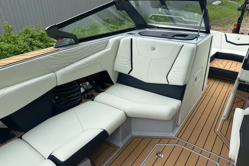 Slide: The Image of 2025 Nautique Super Air Nautique G23 interior with luxurious white seating and teak flooring. - 39