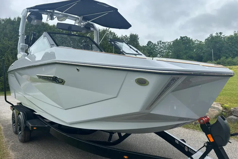Slide: The Image of 2025 Nautique Super Air Nautique G23 boat on trailer, sleek design, overcast day. - 5