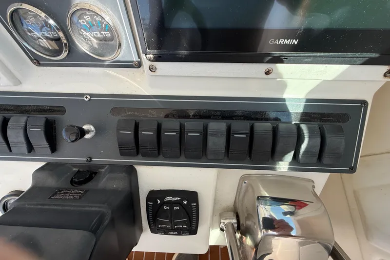 Slide: The Image of Control panel of a 2002 Rampage 30 Express boat with switches and gauges. - 12