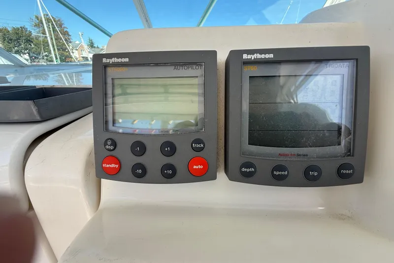 Slide: The Image of Raytheon autopilot and tridata displays on 2002 Rampage 30 Express boat dashboard. - 16