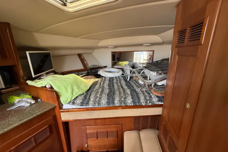 Slide: The Image of Interior cabin of a 2002 Rampage 30 Express boat with bed and TV. - 19