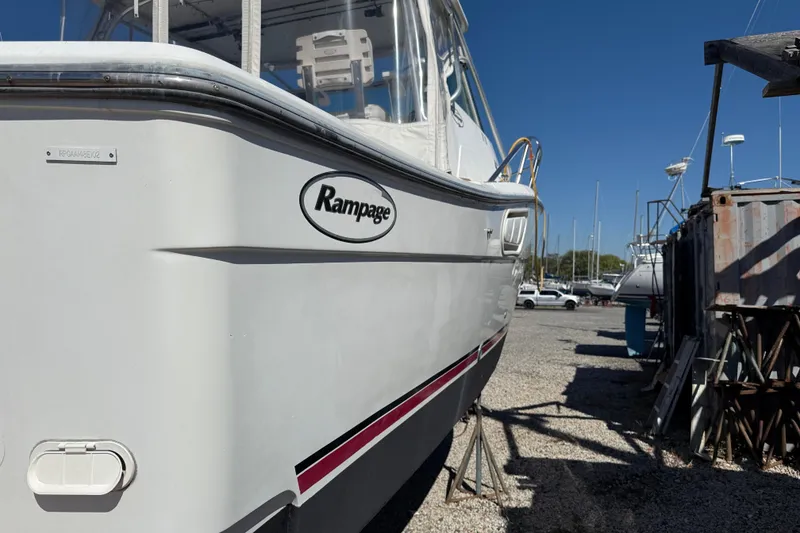 Slide: The Image of 2002 Rampage 30 Express boat on dry dock, side view with logo visible. - 2
