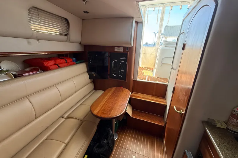 Slide: The Image of Interior of 2002 Rampage 30 Express boat with seating, table, and steps to deck. - 20