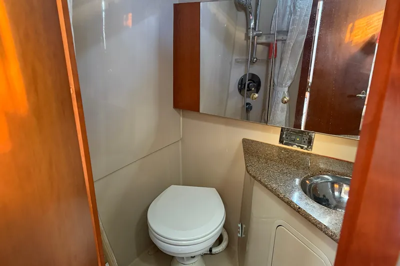 Slide: The Image of 2002 Rampage 30 Express boat bathroom with toilet, sink, and shower. - 24